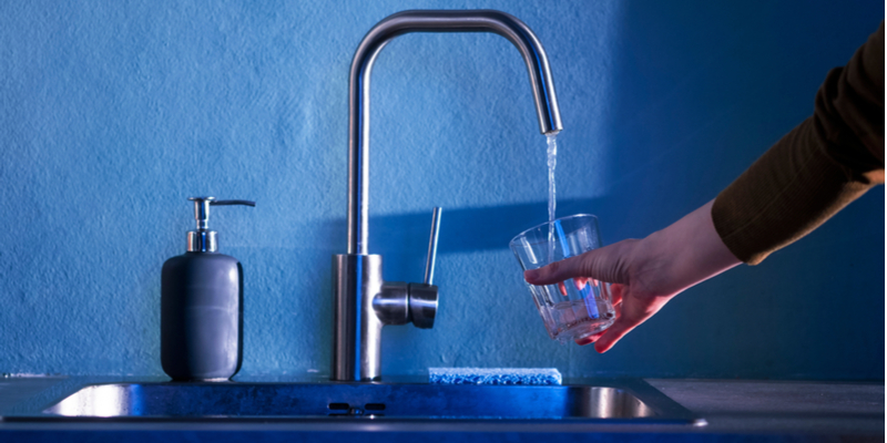 hand of young woman pours clean water